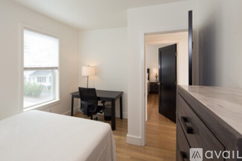 A bedroom with a bed, desk, and chair.