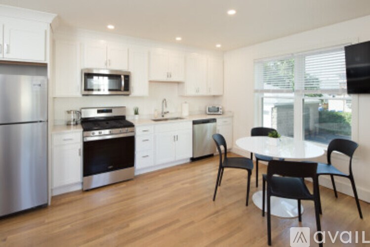 A kitchen with a table and chairs in front of a window.