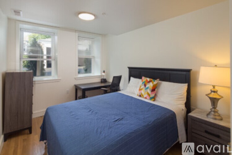 A bedroom with a bed, nightstand, and window.
