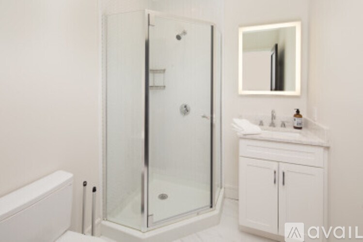 A white bathroom with a glass shower door and a white cabinet.