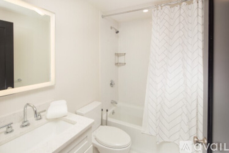 A white bathroom with a sink, toilet, and shower.