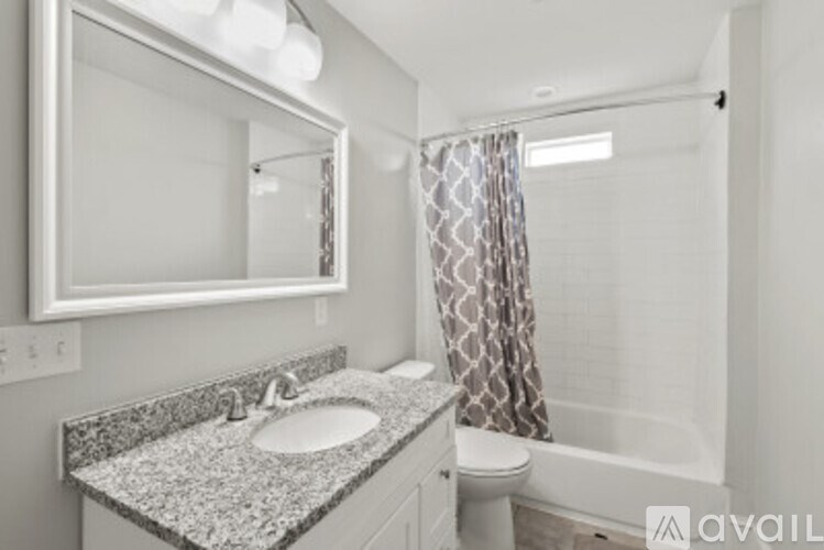 A bathroom with a granite countertop and a white sink.
