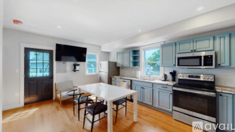 A kitchen with a table and chairs in front of a window.