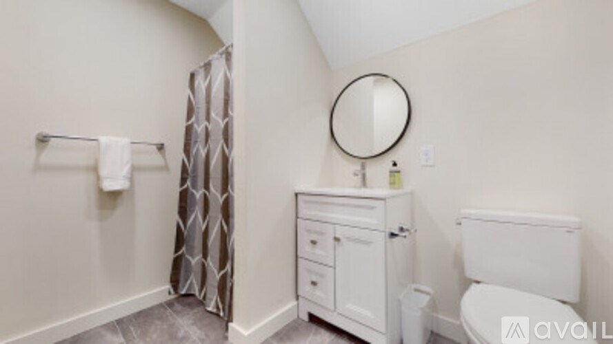 A bathroom with a toilet, sink, and shower curtain.