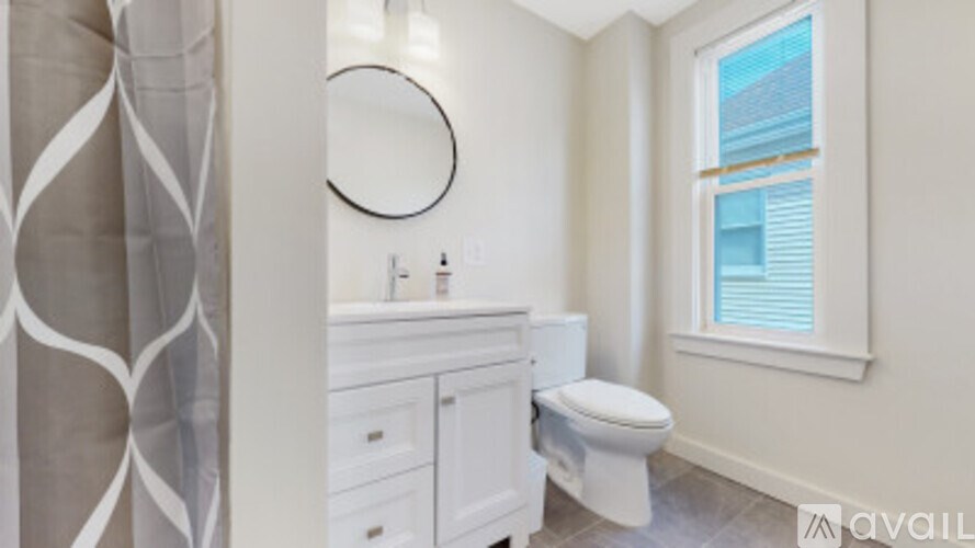A bathroom with a toilet, sink, and a window.