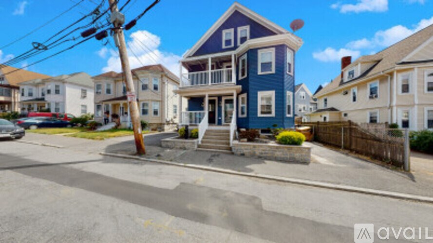 A blue house with a white fence in front of it.