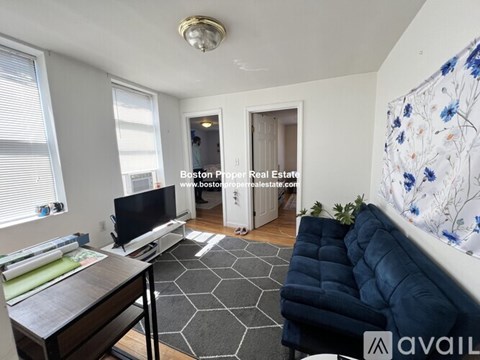 A living room with a blue couch and a television.