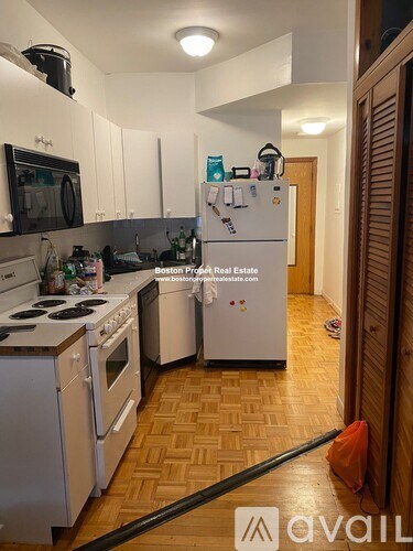 A kitchen with a white fridge and stove top.