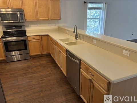 A kitchen with wooden cabinets and a stainless steel oven.