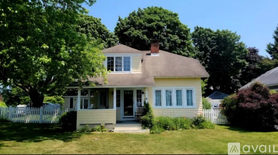 A house with a white picket fence is for sale.