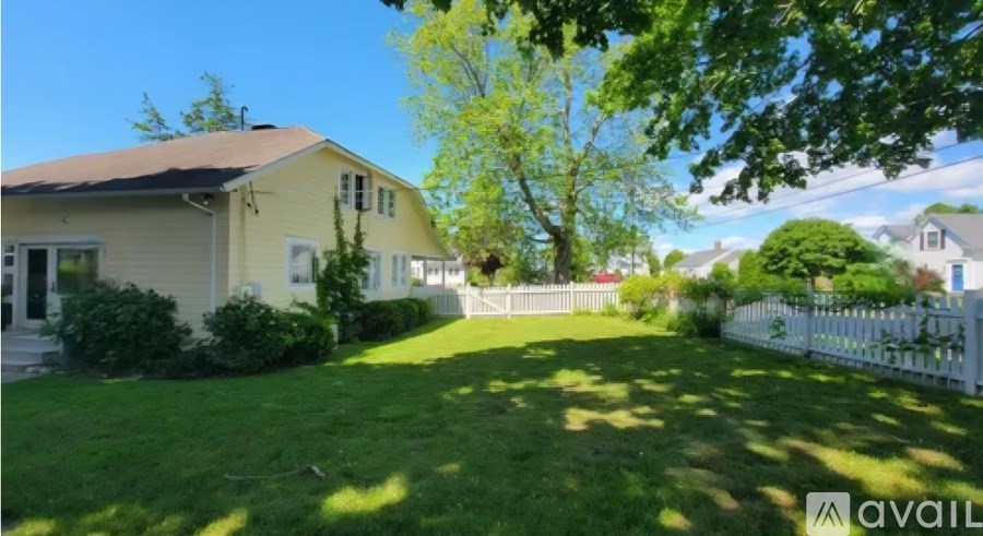 A house with a white picket fence and a green lawn.