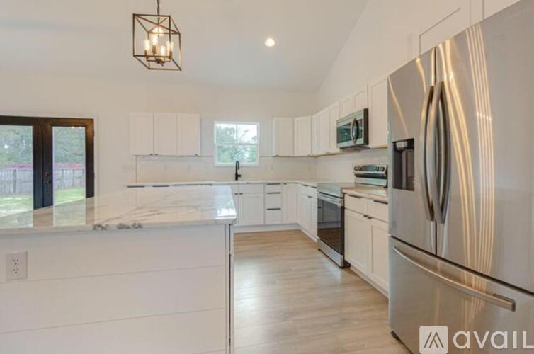 A modern kitchen with white cabinets and stainless steel appliances.