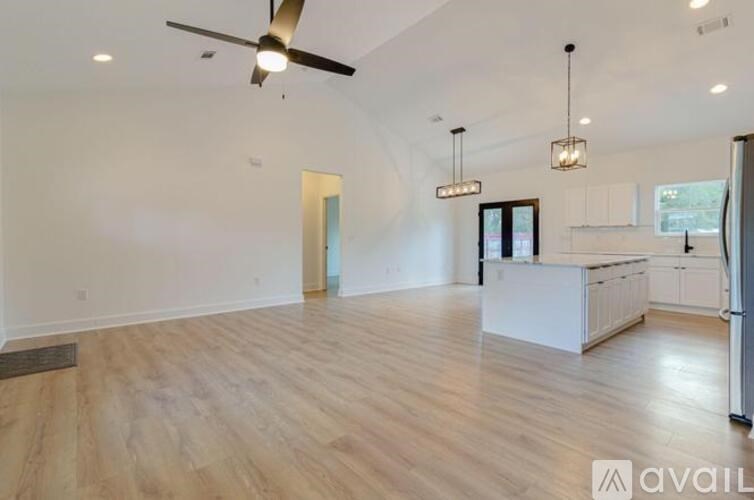 A spacious kitchen with a refrigerator, cabinets, and a countertop.