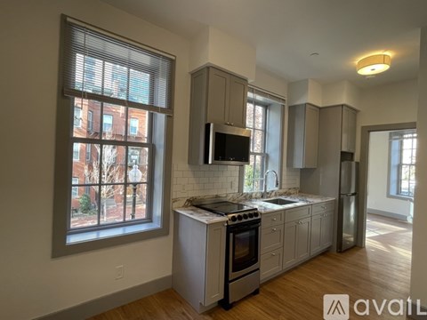 A kitchen with wooden floors and a stove top oven.