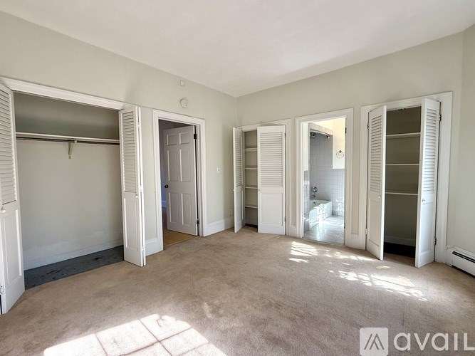 A room with white doors and a carpeted floor.