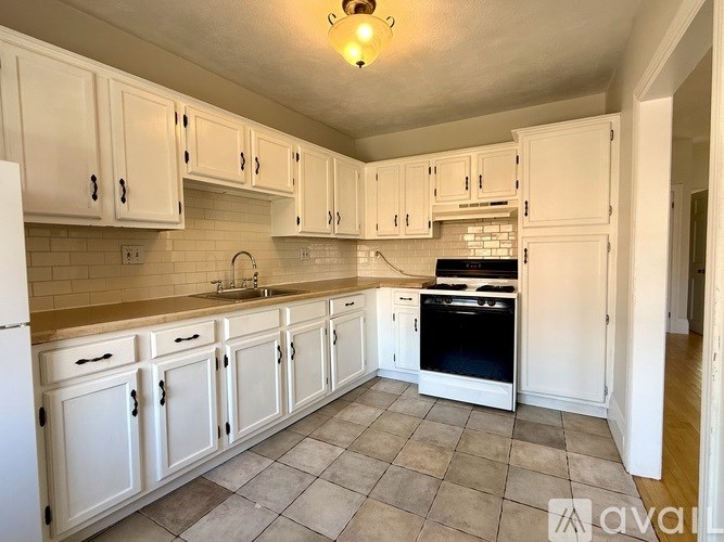 A kitchen with white cabinets and a black oven.