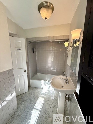 A bathroom with a white tub and sink.