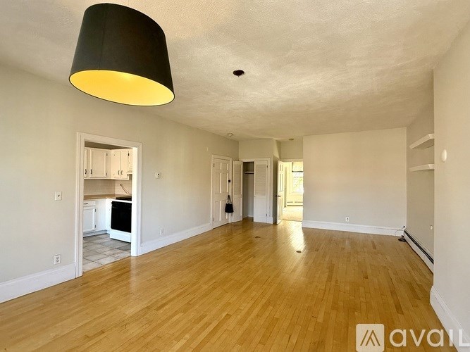 A bathroom with a tub, shower curtain, and sink.