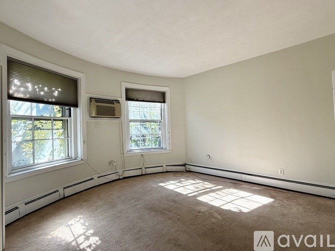 A room with two windows and a carpeted floor.