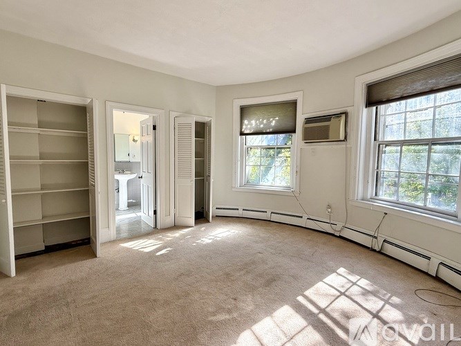 A sunny room with a window, a shelf, and a door leading to another room.