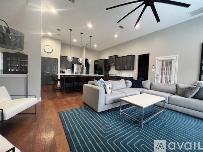 A living room with a white sofa and a patterned rug.