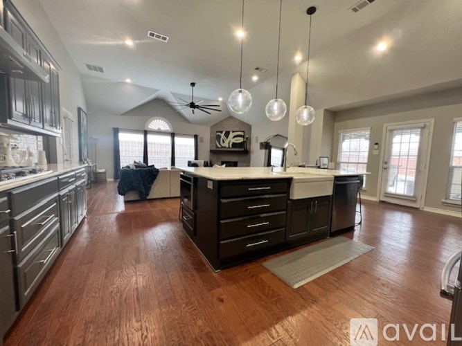 A spacious kitchen with dark wood floors and a central island.