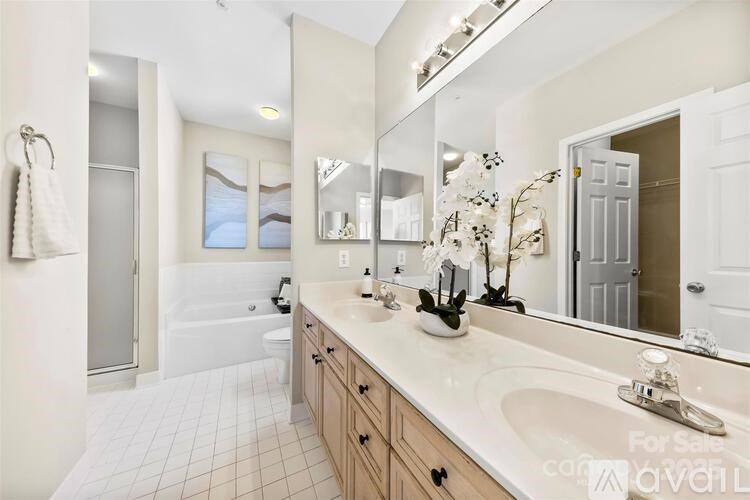 A bathroom with a large mirror, a sink, and a bathtub.