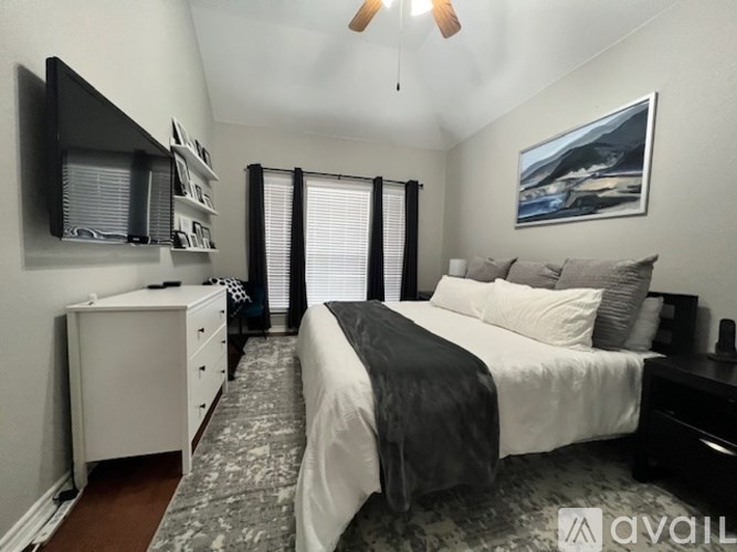 A bedroom with a bed, dresser, and a painting on the wall.
