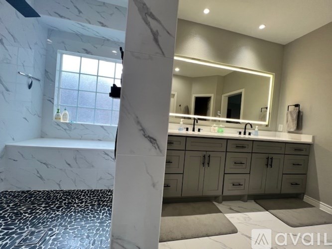 A bathroom with marble flooring and a marble column.