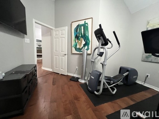 A room with a wooden floor and a stationary bike.