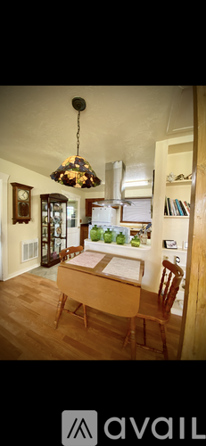 A dining room with a wooden table and chairs.