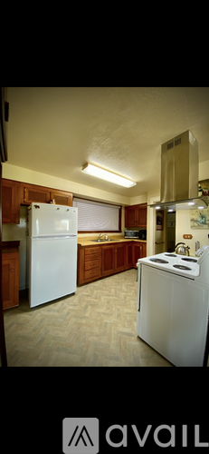 A kitchen with white appliances and wooden cabinets.