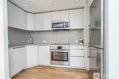 A kitchen with white cabinets and stainless steel appliances.