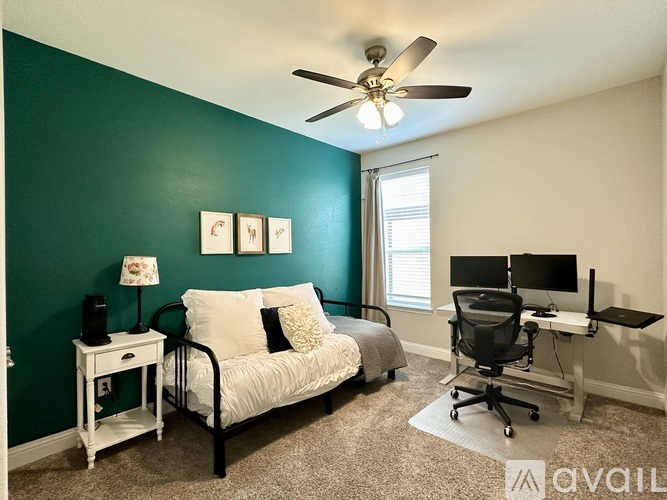 A room with a bed, desk, and chair.