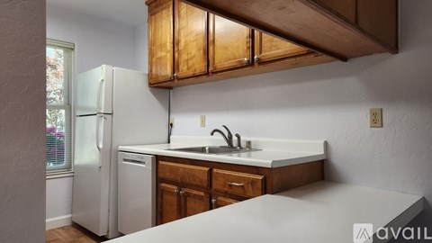 A kitchen with wooden cabinets and a white refrigerator.