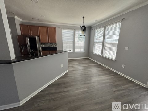 A kitchen with wooden cabinets and a black fridge.