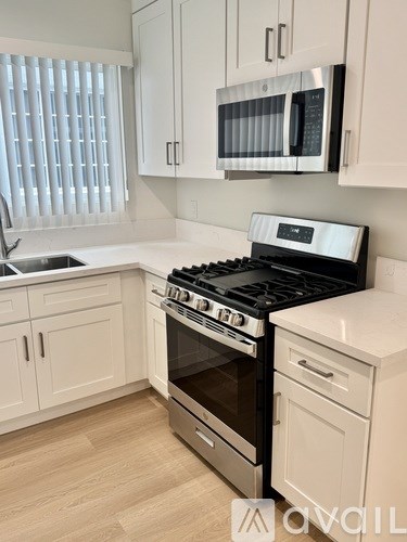 A kitchen with a stove, oven, and microwave.