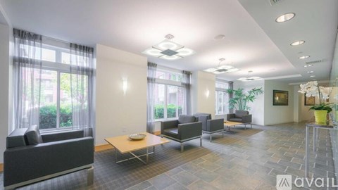A spacious living room with a large window, a sofa set, and a coffee table.
