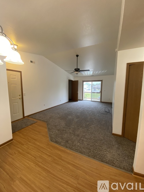 A room with a ceiling fan and a door leading to a balcony.
