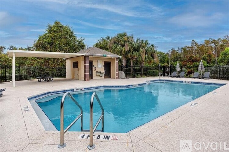 A pool with a ladder and a small building next to it.