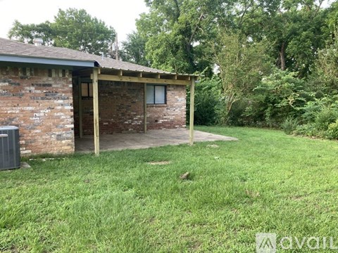 A small house with a brown brick exterior and a wooden porch.