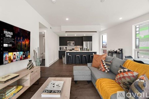 A living room with a grey couch and a coffee table in front of a TV.