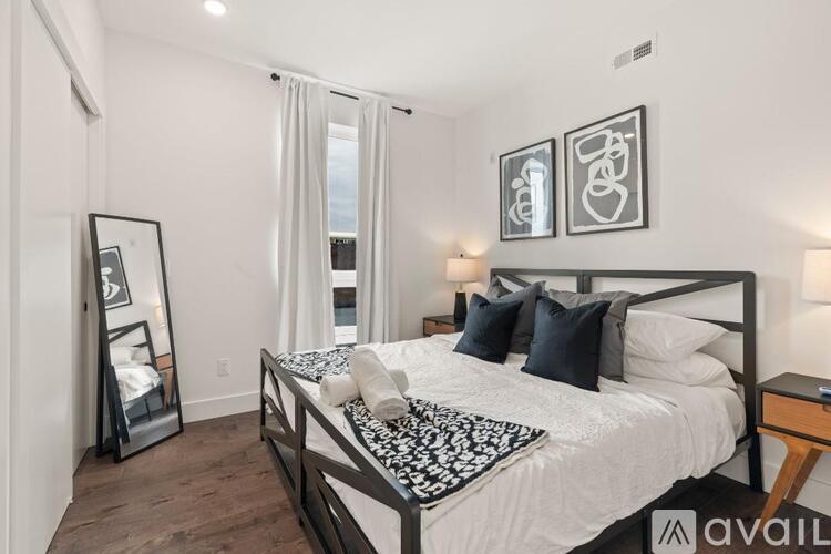 A bedroom with a large bed and a mirror on the wall.