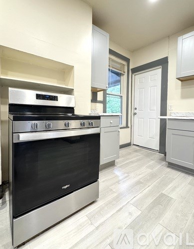 A modern kitchen with a stainless steel oven and white cabinets.
