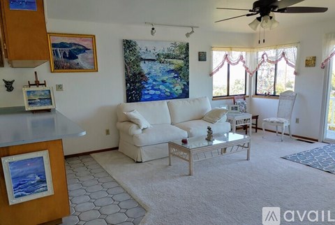 A living room with a painting of a bridge on the wall.