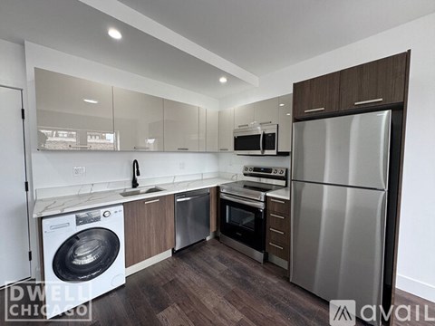 A modern kitchen with a refrigerator, oven, and washing machine.