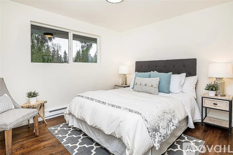 A bedroom with a large bed and a chair.