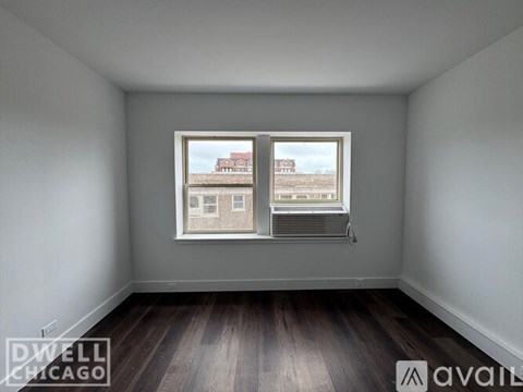 A room with a window showing a view of a building outside.