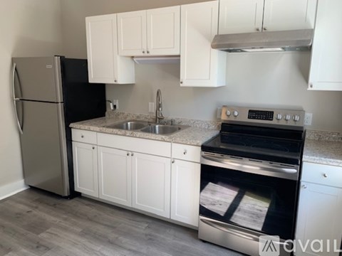 A kitchen with white cabinets and a black oven.