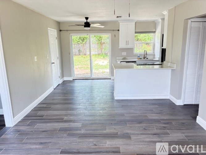 A kitchen with a white countertop and a ceiling fan.